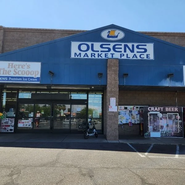 Front entrance of Olsens Marketplace IGA in Ajo, Arizona under a blue sky