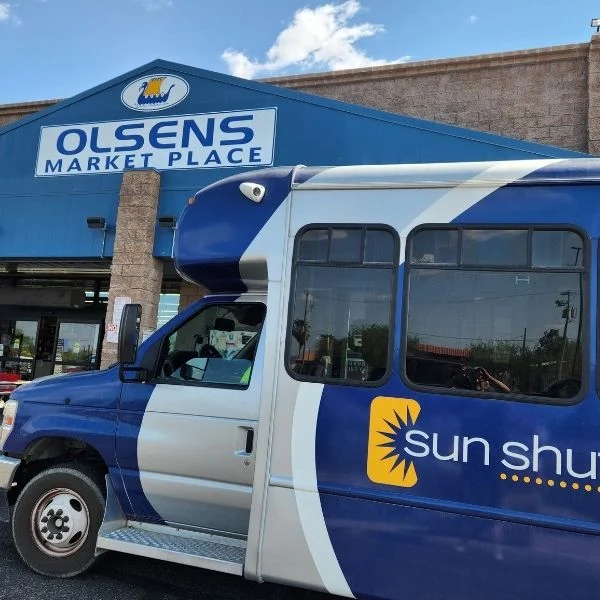 Sun Shuttle bus stopped in front of Olsens Marketplace IGA