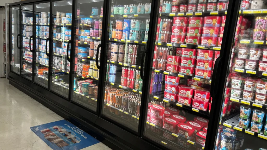 Frozen foods aisle lined with glass-door freezers at Olsens Marketplace