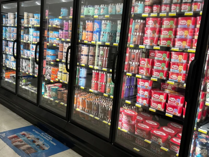 Frozen foods aisle lined with glass-door freezers at Olsens Marketplace