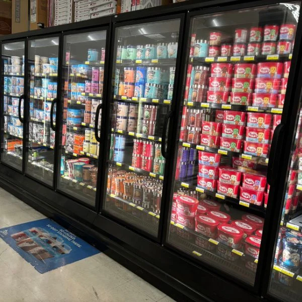 Glass-door freezers in the frozen foods aisle at Olsens Marketplace