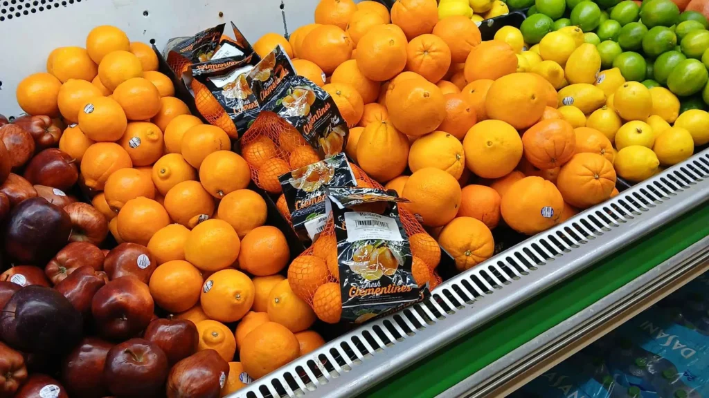 Display of fresh oranges, red apples and bagged citrus in the Tonto Basin Market produce department