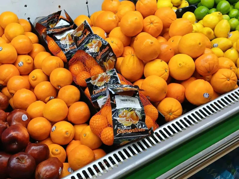 Display of fresh oranges, red apples and bagged citrus in the Tonto Basin Market produce department