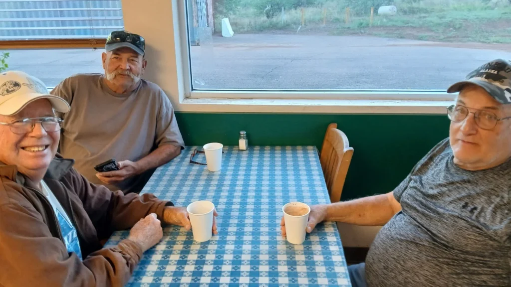 Customers enjoying coffee at a table in the deli dining area at Tonto Basin Market